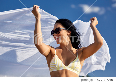woman in bikini swimsuit with cover-up over sky woman in bikini swimsuit with cover-up over sky 87731546