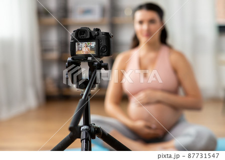 pregnant woman or yoga blogger with camera at home pregnant woman or yoga blogger with camera at home 87731547