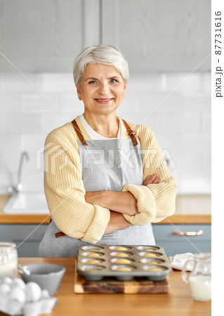 woman with cupcakes in baking mold on kitchen woman with cupcakes in baking mold on kitchen 87731616