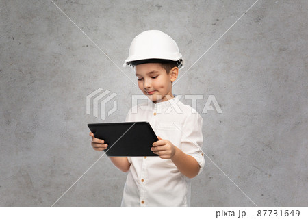 little boy in construction helmet with tablet pc little boy in construction helmet with tablet pc 87731649