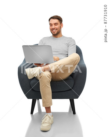 smiling man with laptop sitting in chair smiling man with laptop sitting in chair 87731910