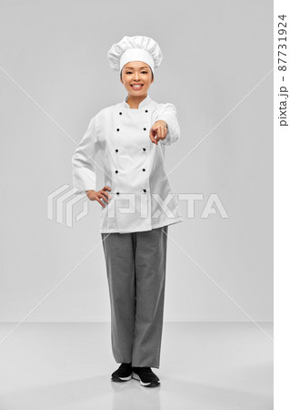 smiling female chef pointing finger to camera smiling female chef pointing finger to camera 87731924