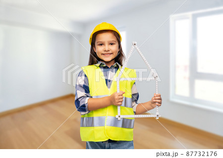 little girl in helmet with ruler in shape of house 87732176