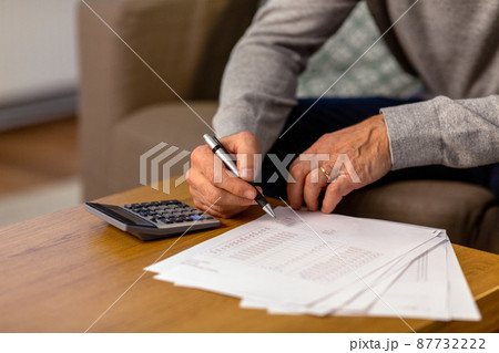 senior man with bills and calculator at home 87732222