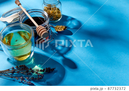 cup of herbal tea, honey and dry chamomile flowers cup of herbal tea, honey and dry chamomile flowers 87732372