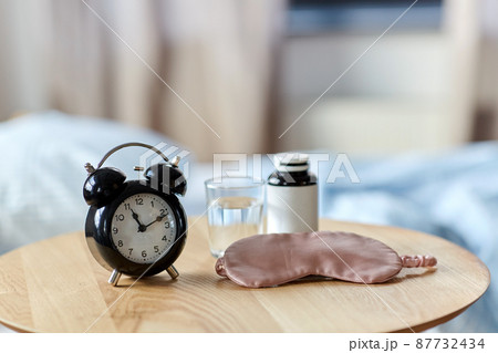 alarm clock, mask and sleeping pills on table alarm clock, mask and sleeping pills on table 87732434