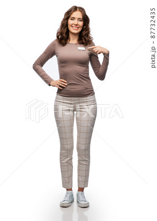 happy female shop assistant showing her name tag happy female shop assistant showing her name tag 87732435