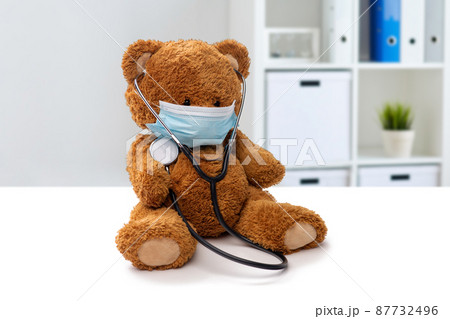 teddy bear toy in medical mask at clinic 87732496