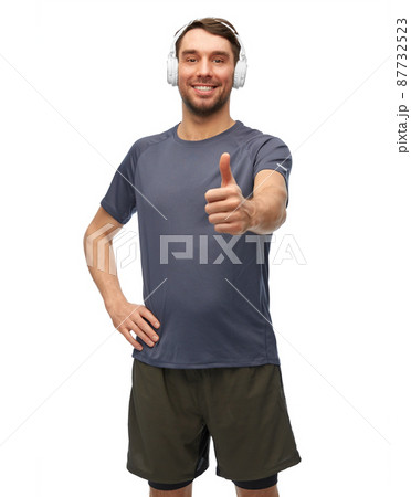 smiling man in sports clothes with headphones 87732523