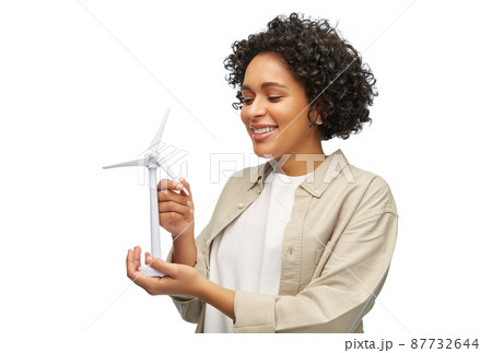 happy woman holding toy wind turbine happy woman holding toy wind turbine 87732644