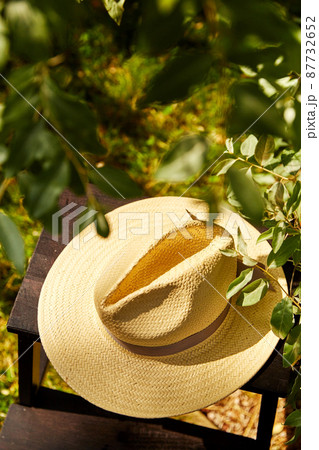 close up of straw hat on stool at summer garden close up of straw hat on stool at summer garden 87732652