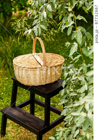 close up of picnic basket on stool in garden close up of picnic basket on stool in garden 87732667