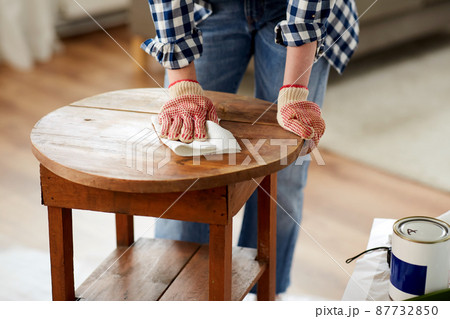woman cleaning old table surface with paper tissue 87732850