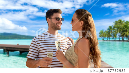 happy couple drinking champagne on summer beach happy couple drinking champagne on summer beach 87732985