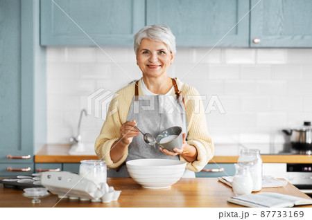 happy woman cooking food on kitchen at home happy woman cooking food on kitchen at home 87733169