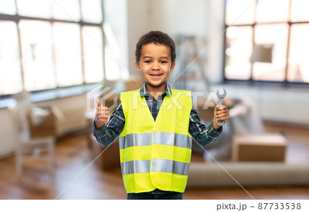 little boy in safety vest with wrench at home little boy in safety vest with wrench at home 87733538