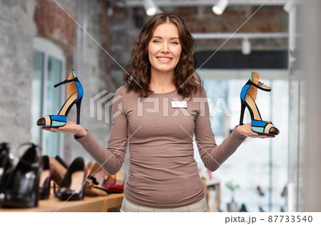happy saleswoman with high-heeled shoes at shop happy saleswoman with high-heeled shoes at shop 87733540