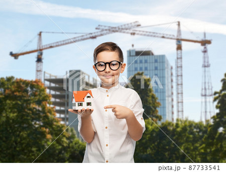 boy in glasses with toy house at construction site 87733541