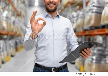 businessman with clipboard at warehouse showing ok businessman with clipboard at warehouse showing ok 87733658