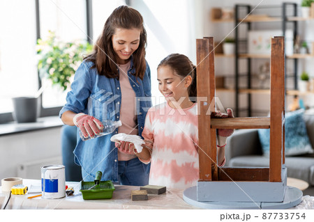 mother and daughter using paint remover for table 87733754