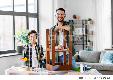 father and son with ruler measuring old table father and son with ruler measuring old table 87733938