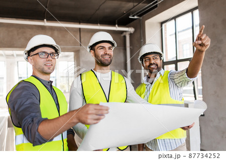 architects in helmets with blueprint at office 87734252