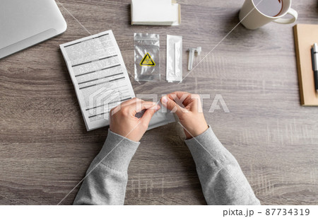 woman unpacking coronavirus test kit at home 87734319