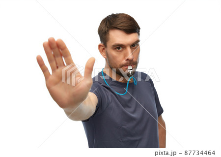 trainer or referee with whistle showing stop gesture trainer or referee with whistle showing stop gesture 87734464
