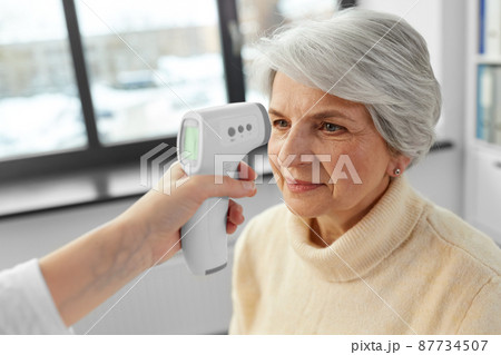 doctor with thermometer and woman at hospital 87734507