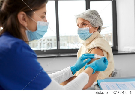 nurse applying medical patch to vaccinated woman nurse applying medical patch to vaccinated woman 87734514