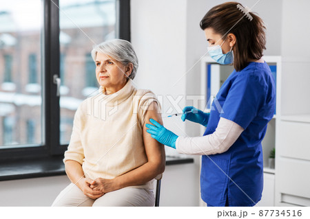 nurse with syringe making injection to woman nurse with syringe making injection to woman 87734516