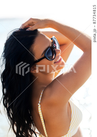 smiling young woman in bikini swimsuit on beach 87734815