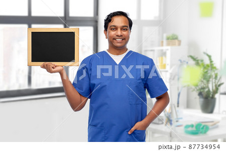 happy male doctor or nurse with chalkboard 87734954