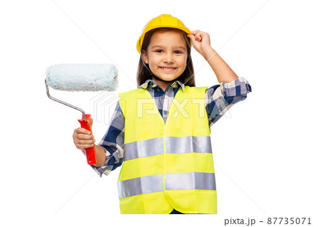 girl in helmet and safety vest with paint roller girl in helmet and safety vest with paint roller 87735071