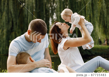 Happy family have a picnic in park near the lake Happy family have a picnic in park near the lake 87735483