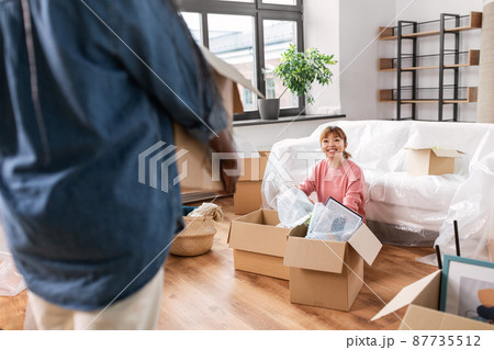 woman unpacking boxes and moving to new home 87735512