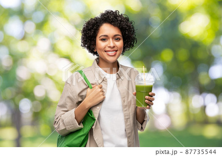 woman with reusable shopping bag drinking smoothie woman with reusable shopping bag drinking smoothie 87735544