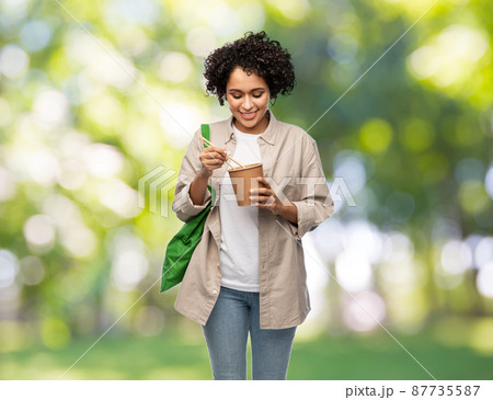 woman with green reusable shopping bag and wok woman with green reusable shopping bag and wok 87735587