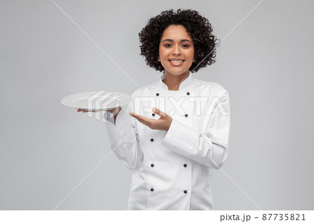 happy smiling female chef holding empty plate 87735821