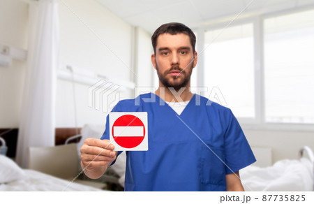 doctor or male nurse showing stop sign at hospital doctor or male nurse showing stop sign at hospital 87735825