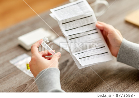 woman reading coronavirus test manual at home woman reading coronavirus test manual at home 87735937