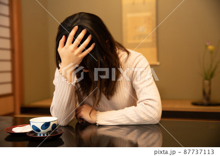 旅館で頭を抱える女性　worries 87737113