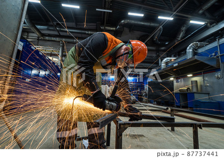 man work in home workshop garage with angle grinder, goggles and construction gloves, sanding metal makes sparks closeup, diy and craft concept man work in home workshop garage with angle grinder, goggles and construction gloves, sanding metal makes sparks closeup, diy and craft concept 87737441