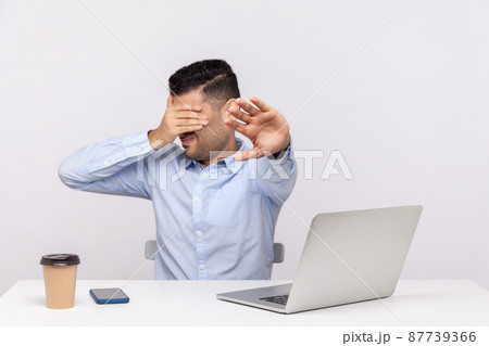 No, don't want to look. Businessman sitting office workplace with laptop on desk, covering eyes showing stop gesture, avoiding watch something unpleasant. studio shot isolated on white background 87739366