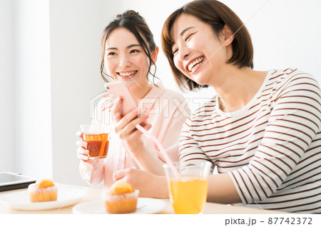 二人でスマホを見る女性 87742372
