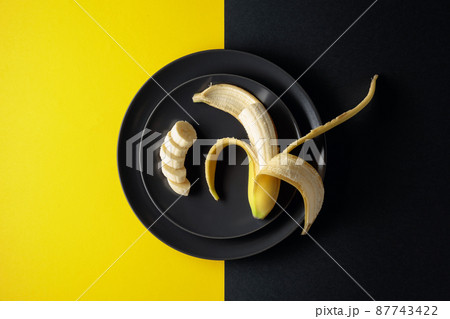 Ripe juicy banana on a black plate. 87743422