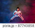 5-year-old elementary school girl, in kimono, practicing martial arts among smoke and colored lights. 87743858