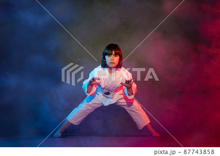 5-year-old elementary school girl, in kimono, practicing martial arts among smoke and colored lights. 5-year-old elementary school girl, in kimono, practicing martial arts among smoke and colored lights. 87743858