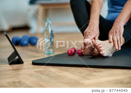 close-up. elderly woman with dumbbells sitting near a laptop . close-up. elderly woman with dumbbells sitting near a laptop . 87744040
