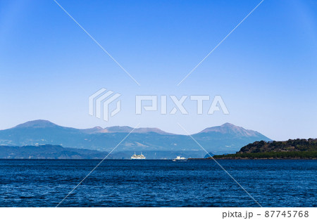 与次郎ヶ浜より錦江湾に浮かぶ霧島連山を望む　錦江湾にはフェリーや船が行き交う 87745768